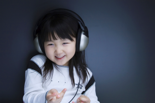 young girl smiling while listening with headphones on
