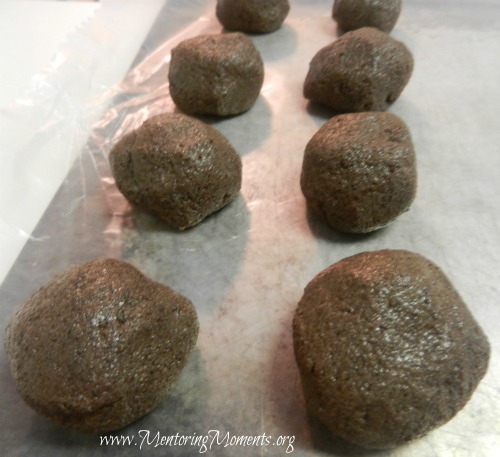 Chocolate fudge cake mixed with mint icing and formed into balls sitting on wax paper.