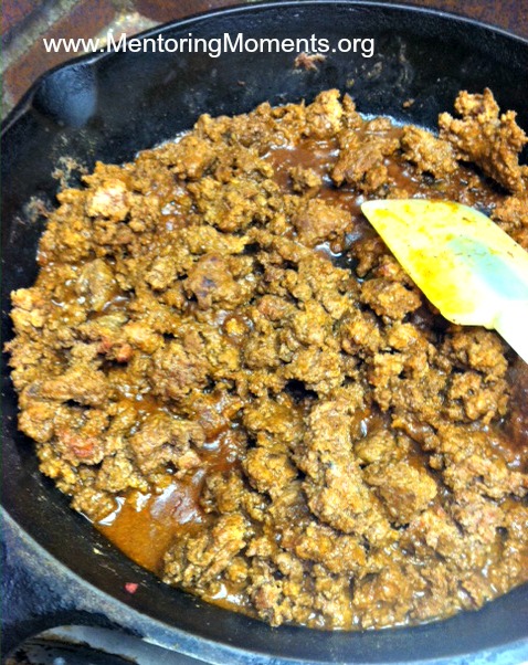 Browning ground beef in an iron skillet with taco seasoning.